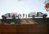 Border Patrol vehicles and agents on a ridge.