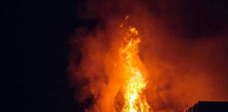 Sirens Chased His Own Fires? Building engulfed in large flames at night.
