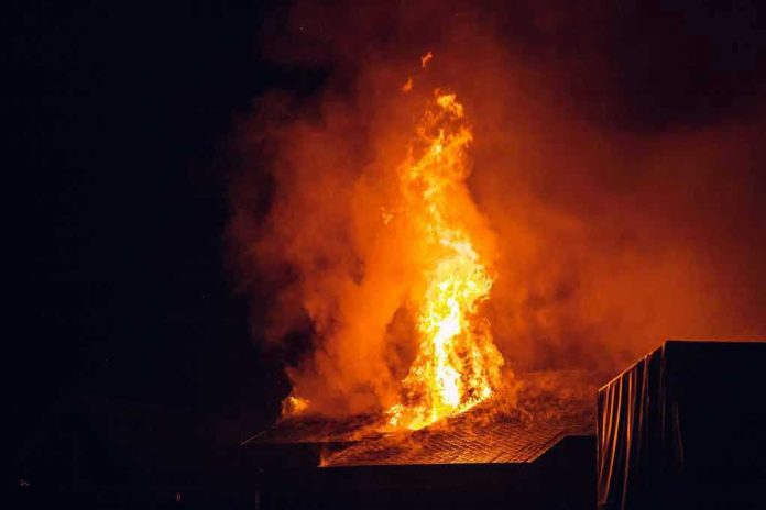 2157190917-1 Building engulfed in large flames at night.