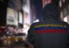 Person in hoodie with Venezuela text standing in a blurred city street