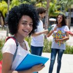 UCLA’s $7,000 Bet On Undocumented Student smiling with folders outdoors near classmates