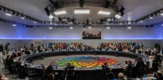 Tech Titans Take a Seat at the G7 Table A large round table meeting with global leaders and flags in the background