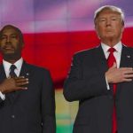 Two men in formal attire standing with hands over their hearts