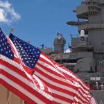 New Allied Strategy Targets Gray Zone Tactics American flags in front of a naval ship under a blue sky