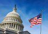 U.S. Capitol building with American flag in foreground.