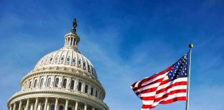 Christian Nation Claim Hits Founders’ Wall U.S. Capitol building with American flag in foreground.