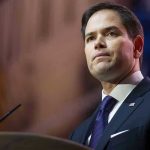 ‘Godless Revolutions’: Speech Divides Critics and Supporters Man in suit speaking at podium.