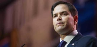 ‘Godless Revolutions’: Speech Divides Critics and Supporters Man in suit speaking at podium.