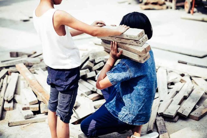 two children handling wooden planks at a work site
