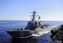 naval destroyer sailing at sea with flag flying