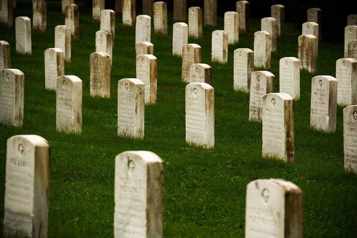 shutterstock_172313045 Rows of gravestones in a cemetery surrounded by green grass