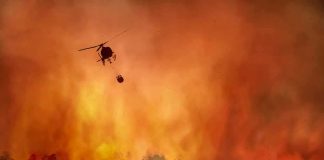 Madrid Wildfires Merge Into a Massive Fire Front Helicopter fights massive wildfire over burning forest