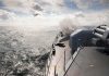 naval warship firing deck gun at sea