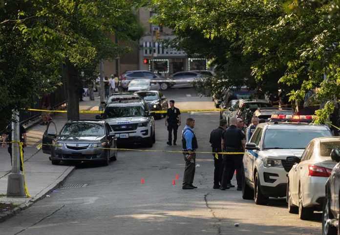 shutterstock_2330301305 Police officers secure a residential street with patrol cars and yellow tape