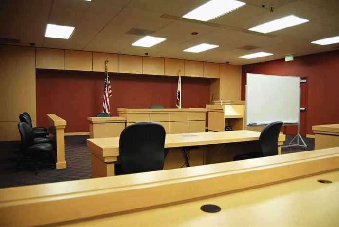 shutterstock_6768826-1 Interior view of an empty courtroom with wooden furniture and American flags