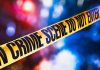 yellow crime scene tape with blurred police lights
