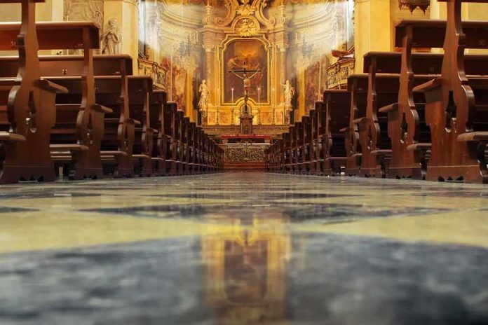 shutterstock_104146931 Church interior with wooden pews facing ornate altar