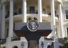 Presidential podium with seal in front of white-columned building