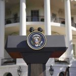 Presidential podium with seal in front of white-columned building