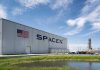 SpaceX hangar beside launch pad under blue sky