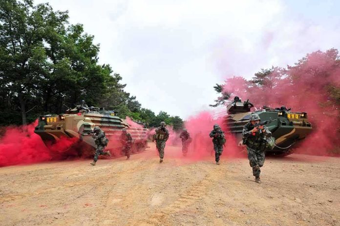 shutterstock_1115301113 Soldiers running with armored vehicles through red smoke