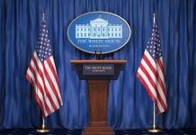 White House press podium with microphones and two American flags