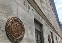 U.S. Treasury building exterior with bronze seal on stone wall
