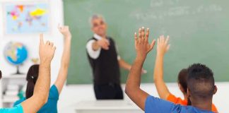 Parents Furious Over Graphic Art Shown to Teens Students raising hands in a classroom while teacher points