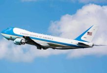 Air Force One aircraft ascending against a blue sky