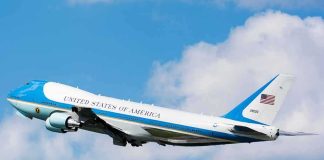 Air Force One aircraft ascending against a blue sky
