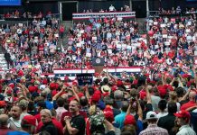 Crowd at a political rally facing a podium