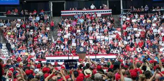 Crowd at a political rally facing a podium