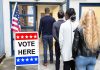 Voters standing in line at a polling place entrance