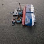 Dozens Missing After Ferry Overturns Capsized cargo ship with salvage vessels alongside