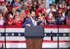 Speaker at podium addressing a rally crowd