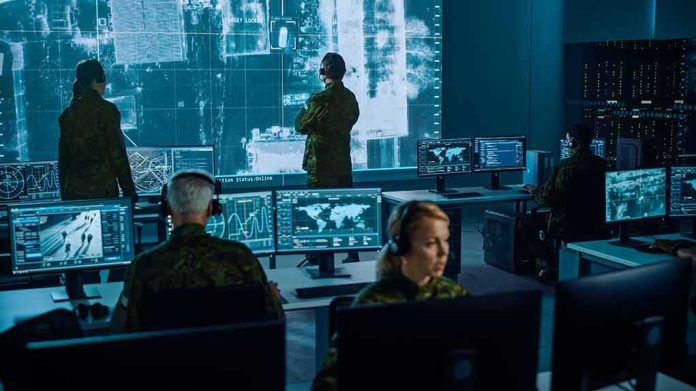 shutterstock_1936992886 Military analysts monitor data on multiple screens in a command center