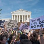 Judge Gives BBC Access to Trump’s Financial Records Protesters with signs outside a neoclassical courthouse