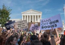 Protesters with signs outside a neoclassical courthouse
