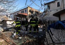 Firefighters assess damage at a collapsed residential building