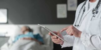 Hospital Horror: Drug Mix-Up Leaves Patients Paralyzed Doctor using tablet beside hospital patient
