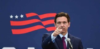 Trump Takes Aim at Tucker Carlson man in suit pointing while speaking at podium