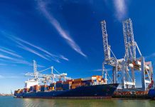 Container ship docked at port with cranes loading cargo