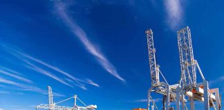 Container ship docked at port with cranes loading cargo