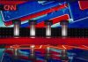 Debate stage with four podiums and colorful star backdrop