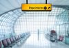 Departures sign hanging in a modern airport terminal