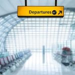 Departures sign hanging in a modern airport terminal