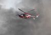Rescue helicopter hovers amid thick smoke