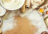 Baking ingredients on a floured wooden surface