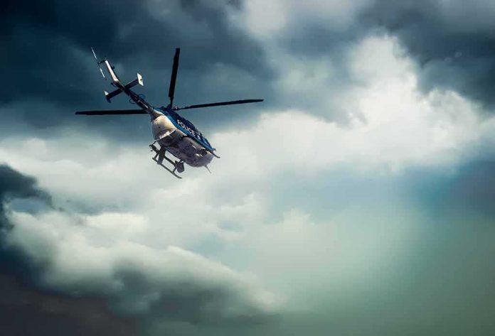 Police helicopter flying under dark storm clouds