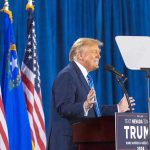 Maher Stuns: Trump Pledge Reads Like Parody Person speaking at podium with flags in background.